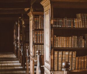Historiskt bibliotek med träskåp och rader av gamla böcker