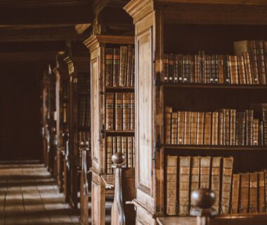 Historiskt bibliotek med träskåp och rader av gamla böcker